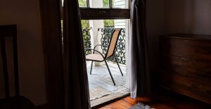 chair through curtains on porch in New Orleans Airbnb